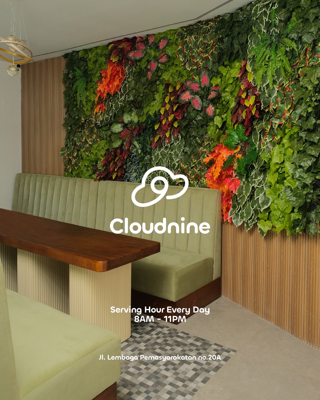 Cloudnine Space cozy sofa area with lush green wall and warm pendant lights